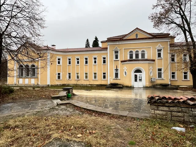 Входната фасада на банята с каменната площадка пред нея.