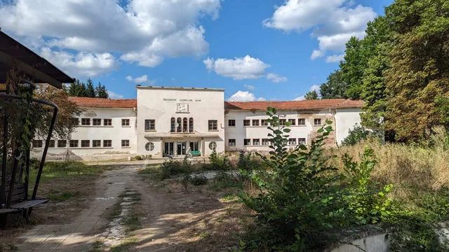 Банята откъм парка, с обраслата алея пред входа.