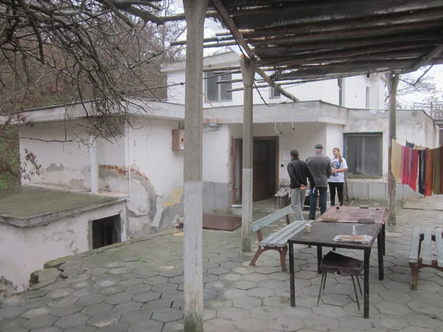 Дворът на баните с навеса, масите и стаите за нощувка.
