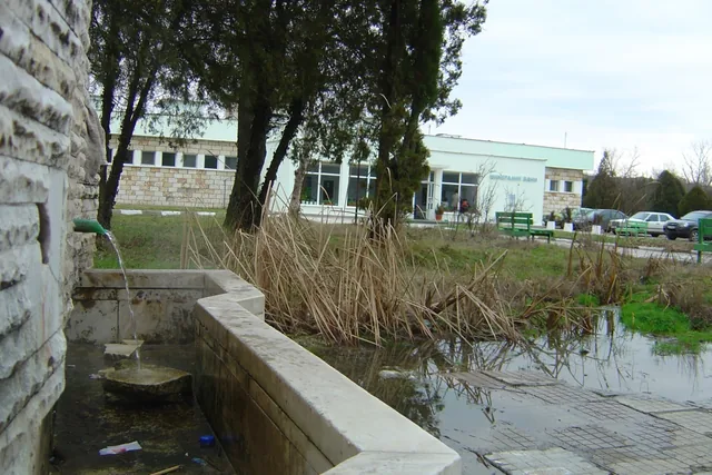 Чучурът с минералната вода пред банята — водата се излива в каменно корито до пътя.