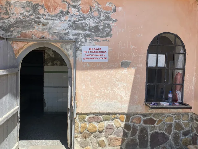 Входът на банята с предупредителната табела за водата.