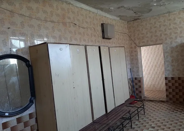 Съблекалнята с кабините и огледалото.
