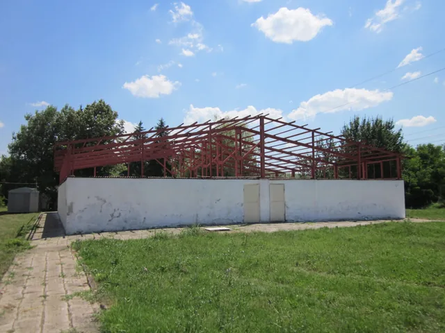 Металната конструкция над лятната къпалня, гледана отвън.