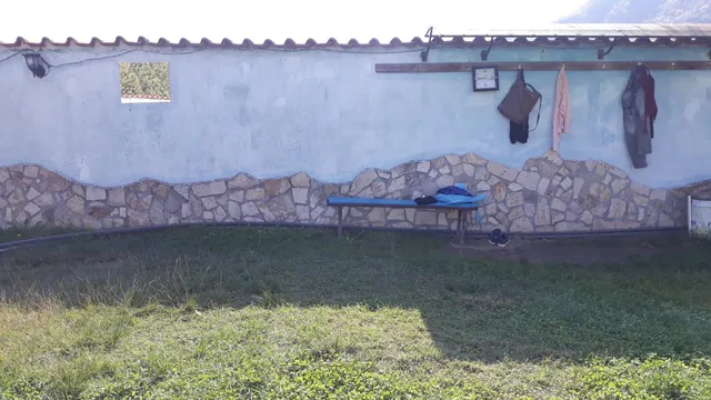 Стената на отделението с окачени дрехи и пейка за преобличане.
