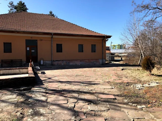 Дългото крило на банята с каменната настилка.