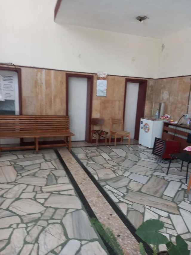 Фоайето на банята с дървените пейки и мозаечния под.